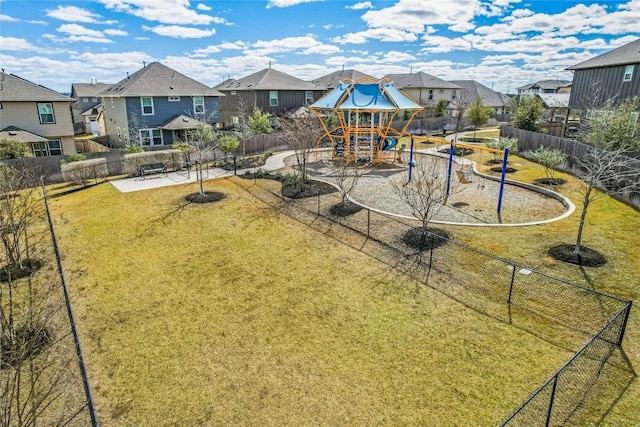 view of jungle gym with a residential view, a lawn, and fence