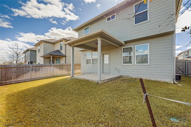 rear view of house featuring a patio area, a lawn, and a fenced backyard