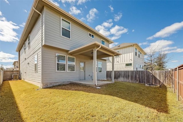 rear view of property featuring a patio area, a fenced backyard, cooling unit, and a yard