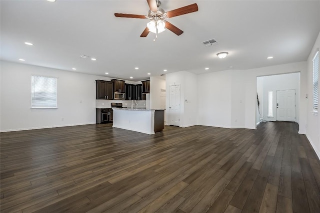 unfurnished living room with dark wood finished floors, recessed lighting, and visible vents