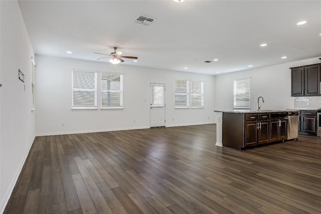 kitchen featuring visible vents, dark brown cabinetry, dark wood-style floors, and open floor plan