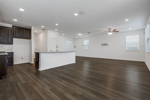 kitchen with visible vents, a sink, tasteful backsplash, open floor plan, and dark wood-style flooring