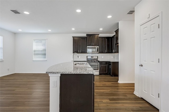 kitchen featuring tasteful backsplash, visible vents, a sink, appliances with stainless steel finishes, and dark wood-style flooring