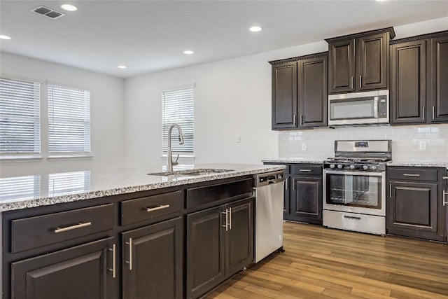 kitchen with visible vents, plenty of natural light, a sink, stainless steel appliances, and light wood-style floors