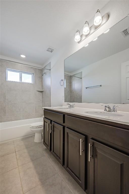 bathroom featuring tile patterned flooring, visible vents, and a sink