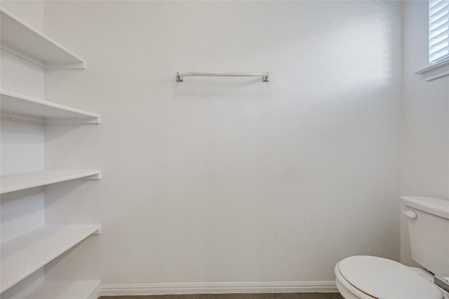 bathroom with baseboards and toilet