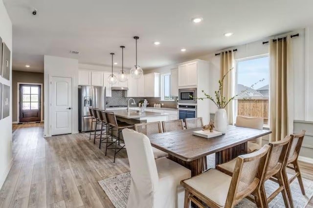 dining room featuring recessed lighting and light wood-style flooring