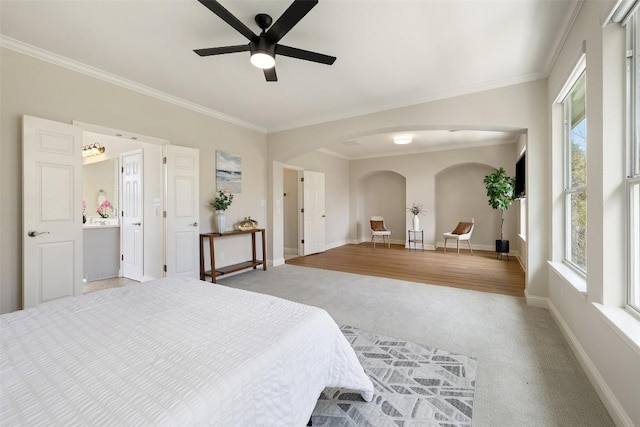 bedroom featuring multiple windows, light colored carpet, and crown molding