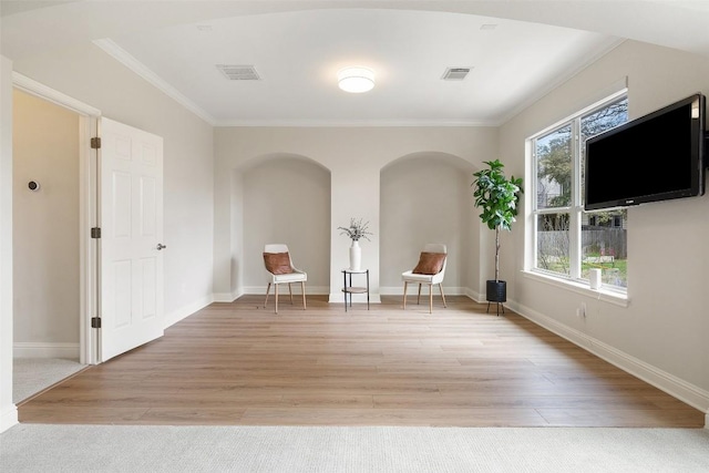 unfurnished room featuring visible vents, baseboards, light wood-style floors, and crown molding