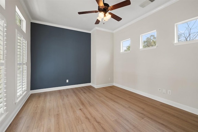 unfurnished room featuring visible vents, plenty of natural light, ornamental molding, and light wood-style flooring