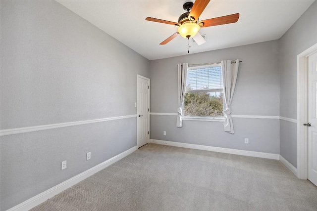 unfurnished room with light colored carpet, baseboards, and ceiling fan