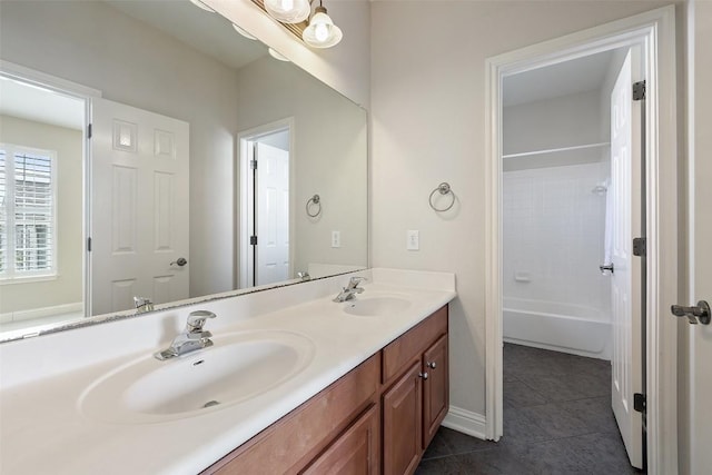 full bathroom with a sink, baseboards, double vanity, and tile patterned flooring