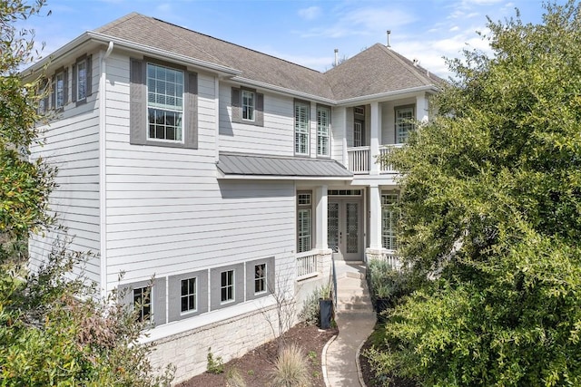 view of front of house featuring french doors and a shingled roof