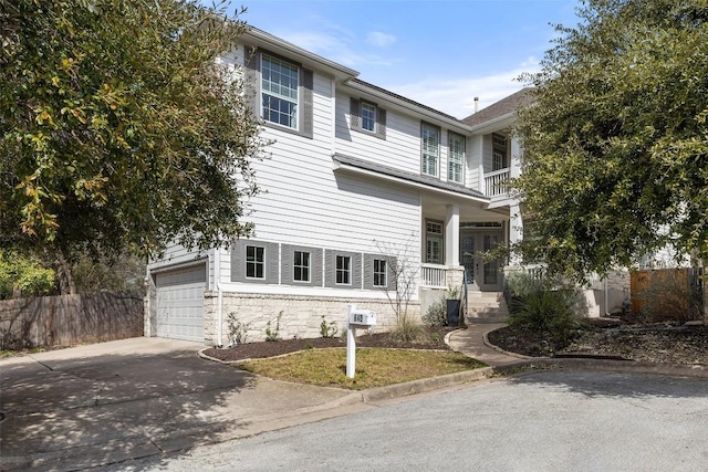 traditional home featuring concrete driveway and fence