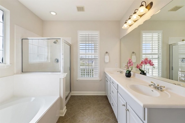 full bathroom with visible vents, double vanity, a sink, a shower stall, and a bath