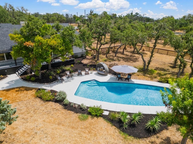 outdoor pool with a patio and fence