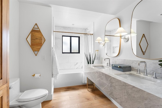 bathroom featuring toilet, wood-type flooring, double vanity, and shower / bath combination with curtain