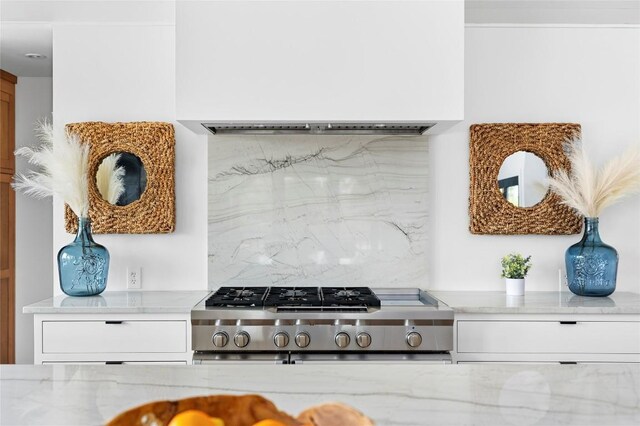 kitchen with backsplash, white cabinets, and light stone countertops