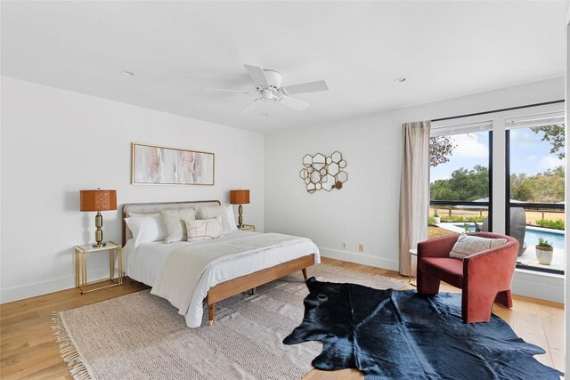 bedroom featuring light wood-style flooring, a ceiling fan, and baseboards