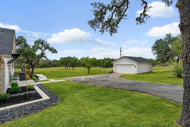 view of grassy yard featuring an outdoor structure and a detached garage