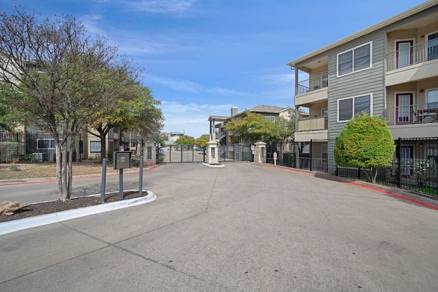 view of street featuring a gated entry, curbs, and a gate