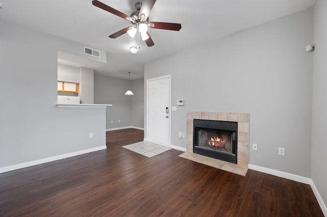 unfurnished living room featuring visible vents, baseboards, wood finished floors, and a fireplace