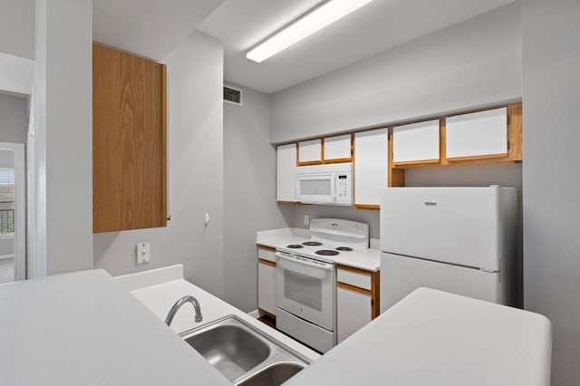 kitchen with visible vents, a sink, white cabinetry, white appliances, and light countertops