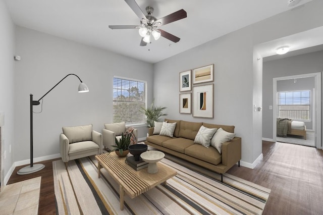 living area featuring baseboards, wood finished floors, and a ceiling fan