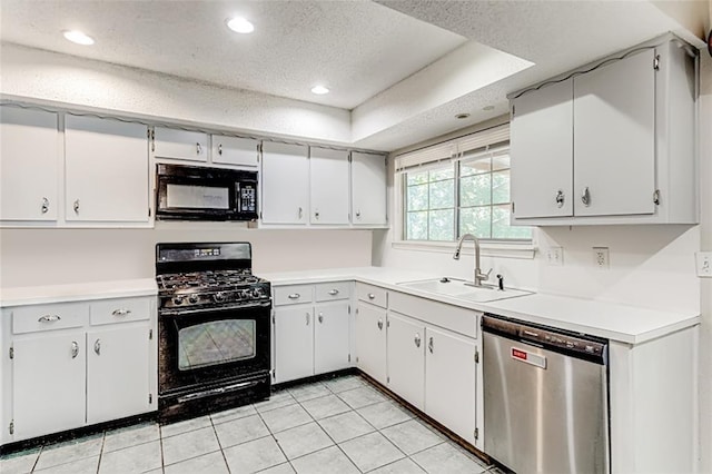 kitchen with a sink, a textured ceiling, black appliances, and light countertops