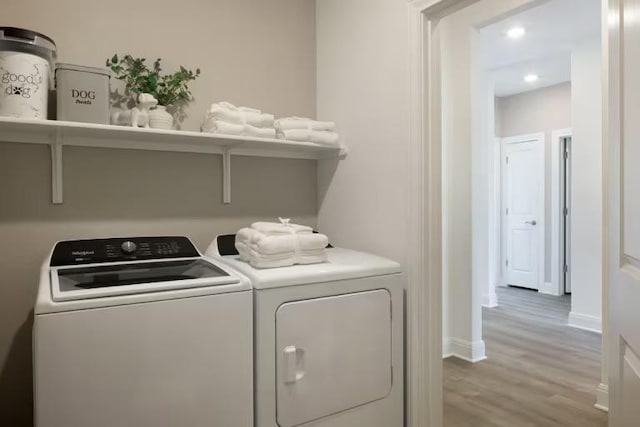 clothes washing area featuring baseboards, washing machine and dryer, laundry area, recessed lighting, and light wood-style floors