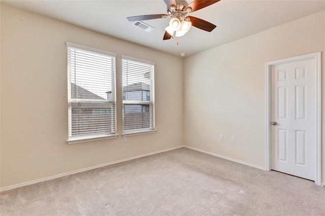 unfurnished room featuring a ceiling fan, carpet flooring, baseboards, and visible vents