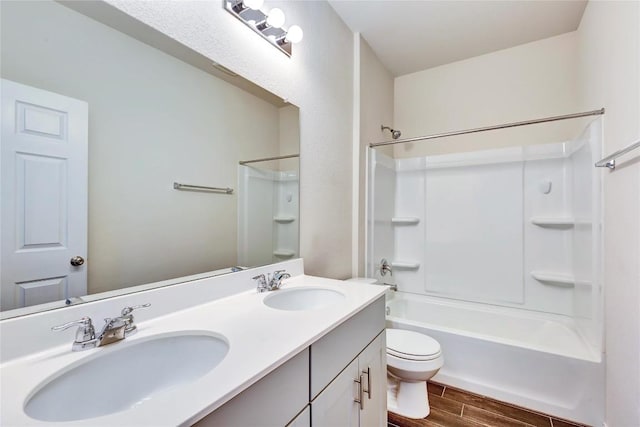 full bath featuring a sink, toilet, double vanity, and wood tiled floor