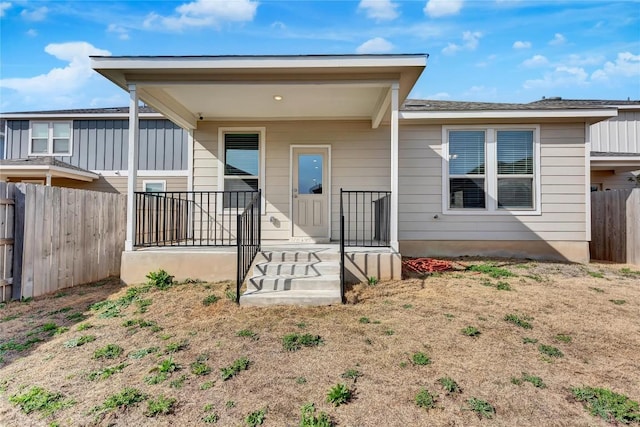 rear view of property featuring fence