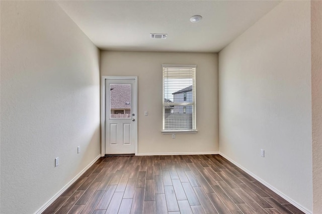 interior space with wood finish floors, visible vents, and baseboards