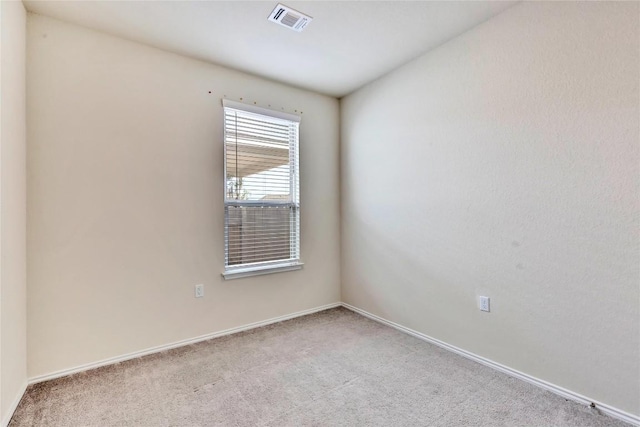 carpeted spare room featuring visible vents and baseboards