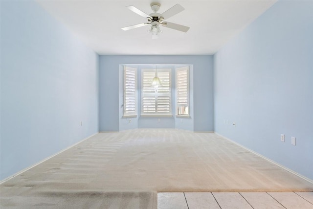 carpeted spare room featuring a ceiling fan