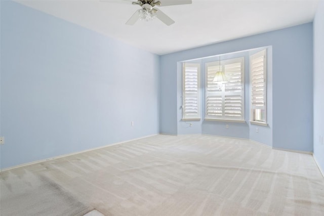 carpeted spare room featuring ceiling fan