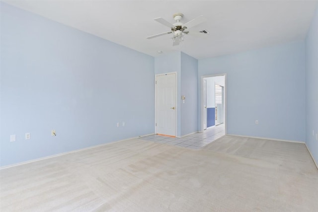 empty room featuring visible vents, baseboards, light colored carpet, and a ceiling fan