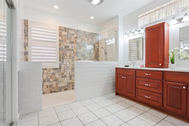 bathroom featuring tile patterned floors, recessed lighting, a walk in shower, and vanity