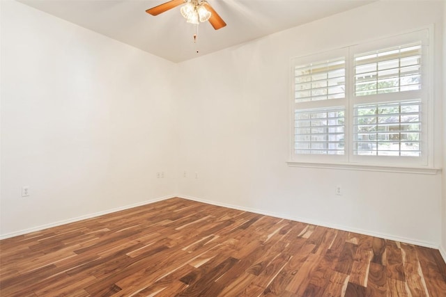 unfurnished room with baseboards, wood finished floors, and a ceiling fan