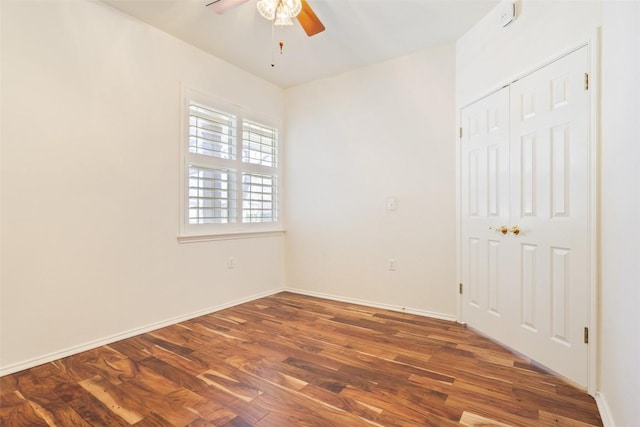 spare room featuring wood finished floors, baseboards, and ceiling fan