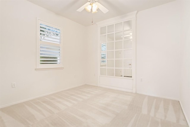 empty room featuring baseboards, carpet, and a ceiling fan