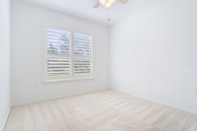 empty room with light colored carpet, baseboards, and ceiling fan