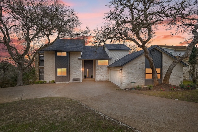 1209 Lost Creek Blvd, Austin, TX 78746 - view of front of home with stone siding, concrete driveway, a garage, and a shingled roof