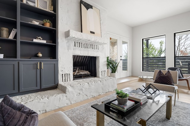 living room featuring a fireplace, french doors, and wood finished floors