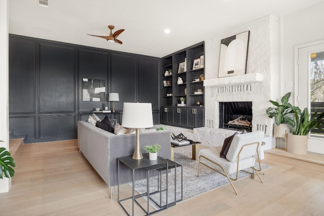 1209 Lost Creek Blvd, Austin, TX 78746 - living area with built in features, a high end fireplace, light wood-style flooring, and a decorative wall