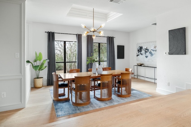 1209 Lost Creek Blvd, Austin, TX 78746 - dining room with light wood-style flooring, a chandelier, and a tray ceiling