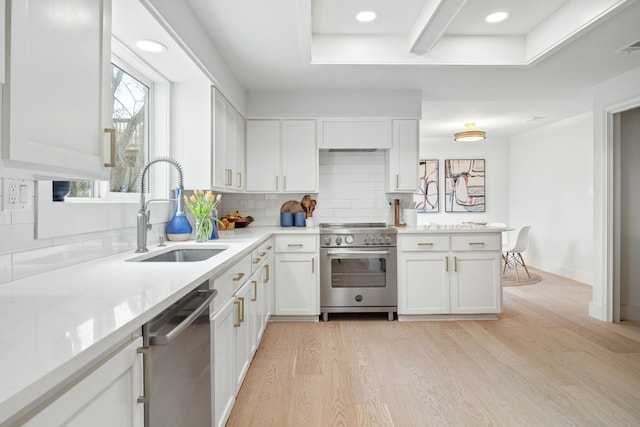 1209 Lost Creek Blvd, Austin, TX 78746 - kitchen featuring appliances with stainless steel finishes, a sink, light wood-style floors, white cabinets, and decorative backsplash