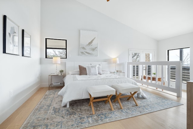 bedroom featuring high vaulted ceiling, baseboards, and wood finished floors