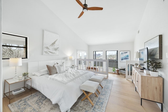 bedroom featuring a ceiling fan, light wood-style floors, visible vents, and high vaulted ceiling